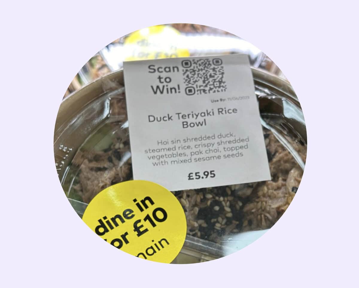 A close-up of a packaged Duck Teriyaki Rice Bowl with a label showing the price (£5.95), description, and a QR code for Restaurant Survey Collection. A yellow sticker mentions "dine in for £10." The packaging is clear plastic.