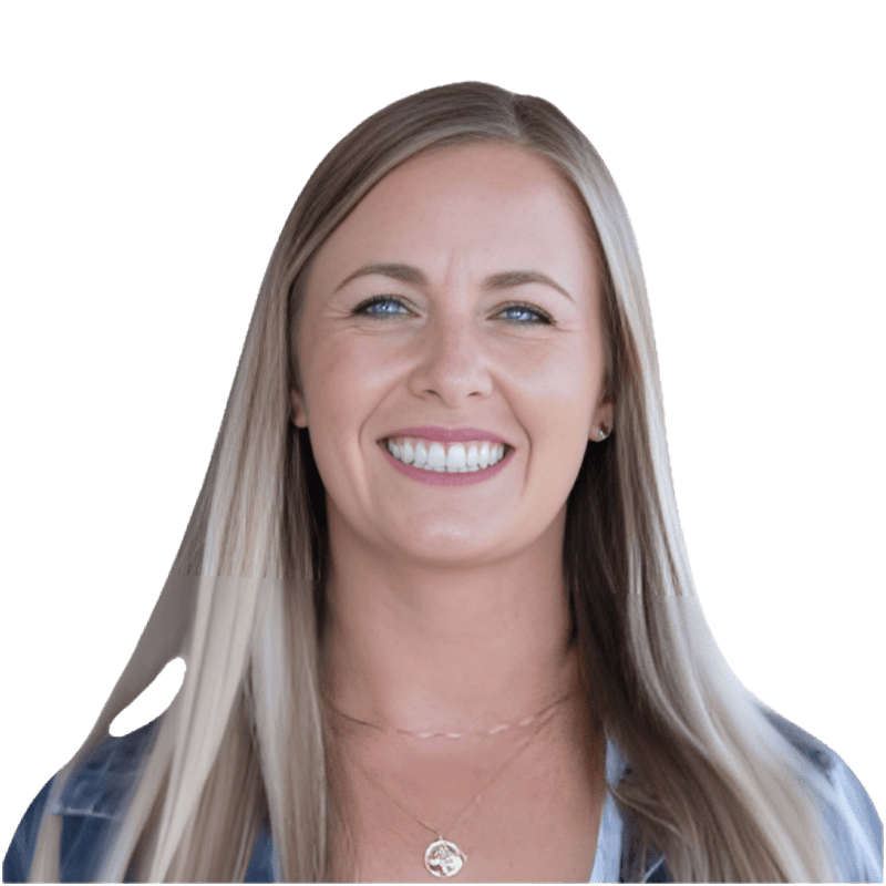A woman with long, straight blonde hair and blue eyes is smiling at the camera. She is wearing a necklace and a patterned top, with a white background—featured in our Case Study: The Restaurant Group on Achieved NPS and Sales Growth With BBI Survey Studio.